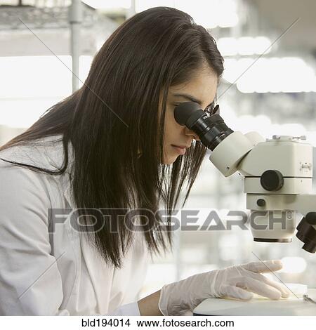 Picture - Indian scientist using microscope in laboratory. Fotosearch