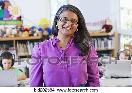 Picture - Indian teacher standing in classroom. Fotosearch