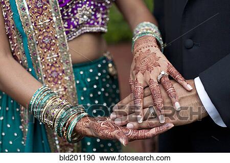 Stock Image - Indian wedding couple with ornate hand decorations. Fotosearch