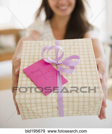 Stock Photo - Indian woman holding out Mother's Day gift. Fotosearch