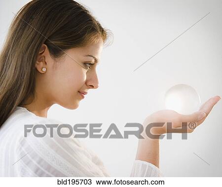 Stock Image - Indian woman looking at glass ball. Fotosearch
