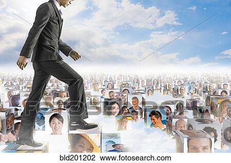 Stock Image - Korean businessman walking over images of business people. Fotosearch