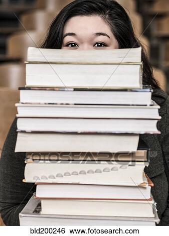 Korean student holding stack of books View Large Photo Image Stock Photograph - Korean student holding stack of books. Fotosearch