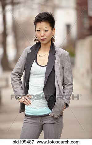 Stock Photo - Korean woman standing with hands on hips. Fotosearch