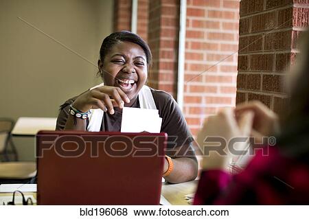 Stock Photo - Laughing African American woman sitting in cafe. Fotosearch