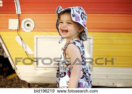 Stock Photo - Laughing Caucasian girl near camper. Fotosearch
