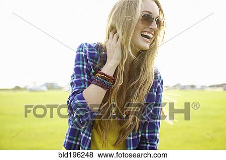 Laughing Caucasian woman standing in field View Large Photo Image Stock Photo - Laughing Caucasian woman standing in field. Fotosearch