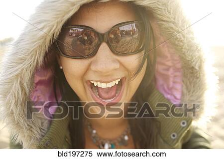 Stock Photography - Laughing mixed race woman in fur hood. Fotosearch