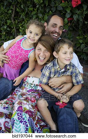 Laughing parents holding children on lap View Large Photo Image Picture - Laughing parents holding children on lap. Fotosearch