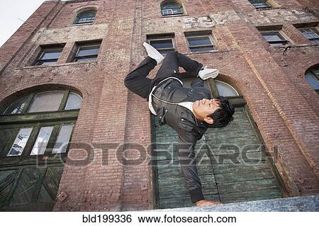 Stock Photograph - Man breakdancing in urban area. Fotosearch