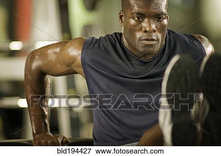 Stock Photo - Man exercising in health club. Fotosearch