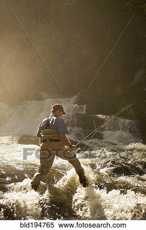 Stock Photography - Man fly fishing in river. Fotosearch