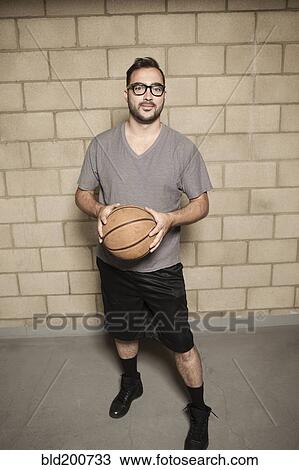 Stock Image - Man holding basketball. Fotosearch