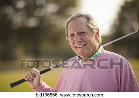Stock Photograph - Man holding golf club. Fotosearch