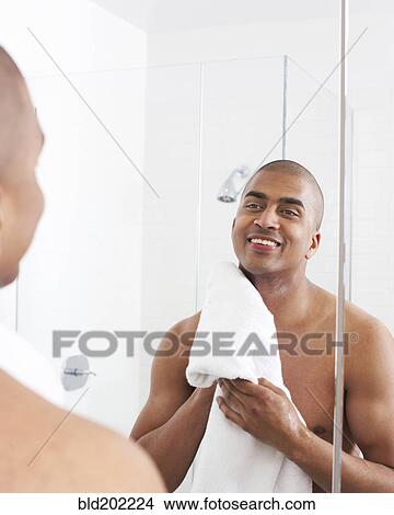 Man in bathroom wiping face with towel View Large Photo Image Picture - Man in bathroom wiping face with towel. Fotosearch