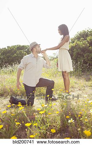 Stock Image - Man kissing girlfriend's hand. Fotosearch
