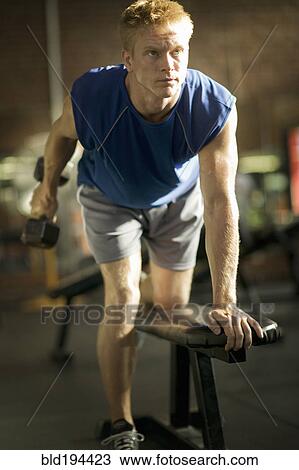 Man lifting weights in health club View Large Photo Image Stock Image - Man lifting weights in health club. Fotosearch