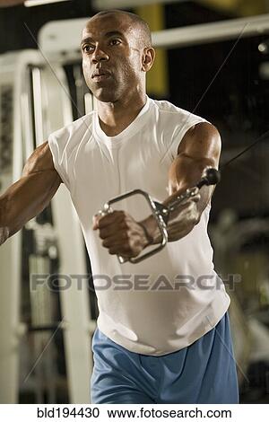 Man lifting weights in health club View Large Photo Image Stock Image - Man lifting weights in health club. Fotosearch