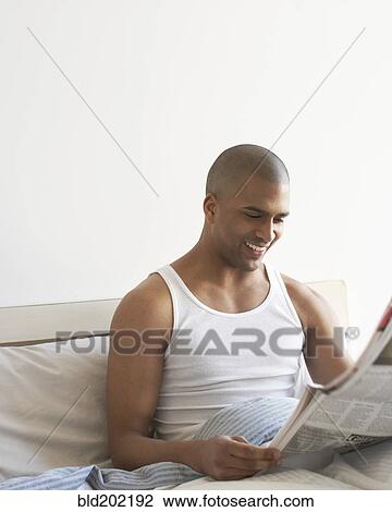 Man reading newspaper in bed View Large Photo Image Stock Image - Man reading newspaper in bed. Fotosearch