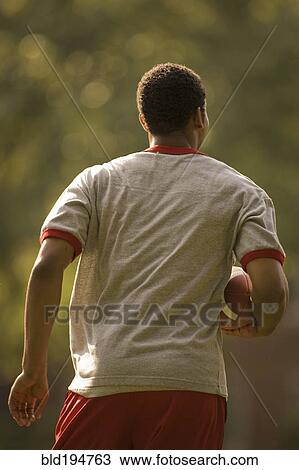 Stock Image - Man running with football. Fotosearch