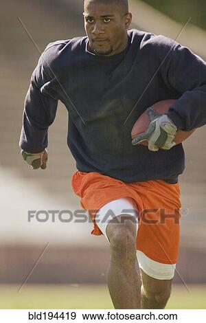 Stock Photo - Man running with football. Fotosearch