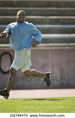 Stock Photography - Man running with football. Fotosearch