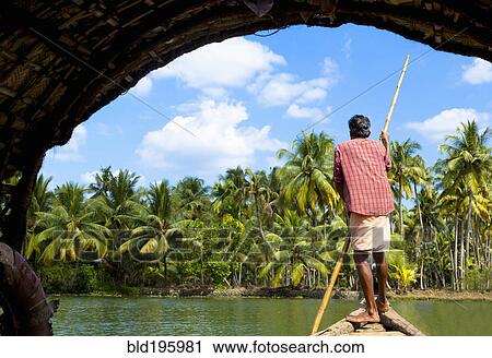 Man standing in boat on tranquil forest river View Large Photo Image Stock Image - Man standing in boat on tranquil forest river. Fotosearch