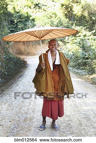 Man standing on dirt road in traditional Laotian clothing View Large Photo Image Picture - Man standing on dirt road in traditional Laotian clothing. Fotosearch