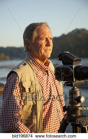 Picture - Man taking photographs on beach. Fotosearch