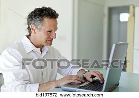 Stock Image - Man typing on laptop. Fotosearch