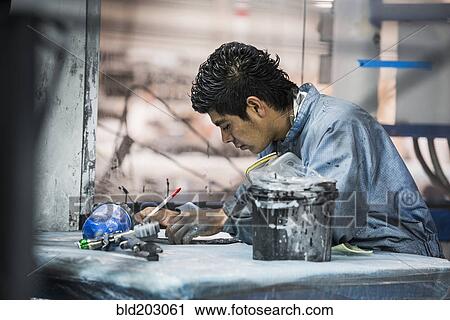 Stock Image - Man working in manufacturing plant. Fotosearch
