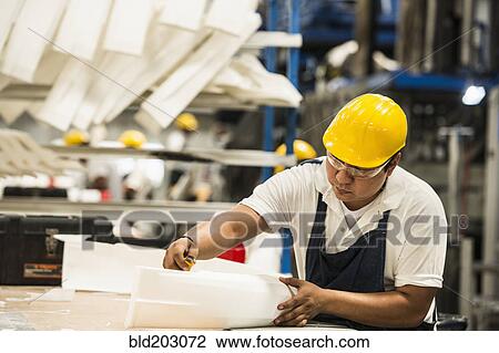 Stock Image - Man working in manufacturing plant. Fotosearch