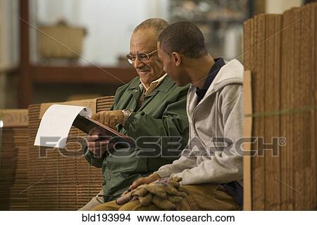 Picture - Manager talking with worker in warehouse. Fotosearch