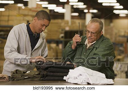 Stock Photography - Manager talking with worker in warehouse. Fotosearch