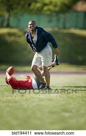 Stock Image - Men playing football. Fotosearch