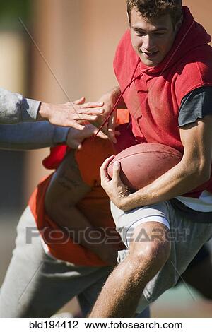 Stock Image - Men playing football. Fotosearch