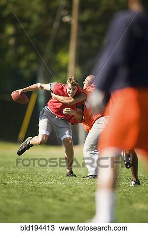 Stock Image - Men playing football. Fotosearch