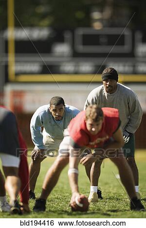 Stock Photograph - Men playing football. Fotosearch