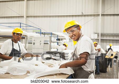 Stock Image - Men working in manufacturing plant. Fotosearch