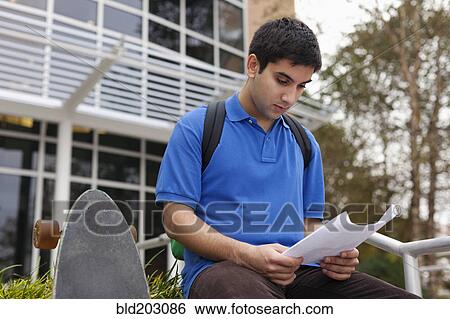 Stock Photograph - Middle Eastern student reading notes on campus. Fotosearch