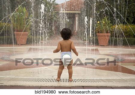 Mixed race baby wearing diaper standing near fountain View Large Photo Image Stock Image - Mixed race baby wearing diaper standing near fountain. Fotosearch