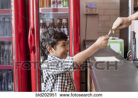 Stock Image - Mixed race boy buying food in restaurant. Fotosearch