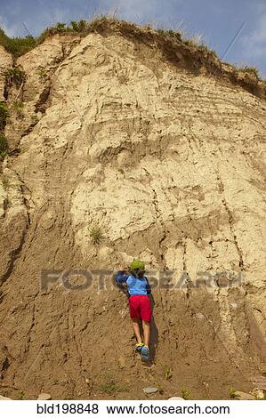 Mixed race boy climbing dirt cliff View Large Photo Image Stock Photo - Mixed race boy climbing dirt cliff. Fotosearch
