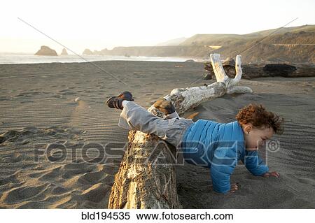Mixed race boy crawling on beach View Large Photo Image Stock Photography - Mixed race boy crawling on beach. Fotosearch