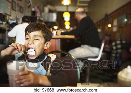 Stock Photo - Mixed race boy eating ice cream. Fotosearch