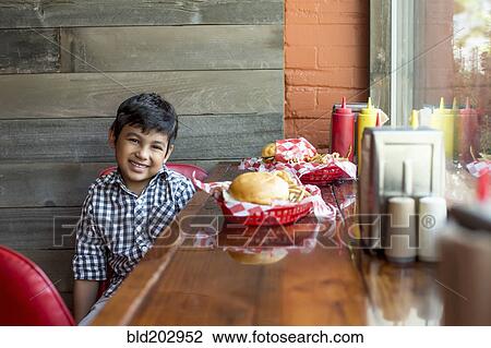 Mixed race boy having burgers in restaurant View Large Photo Image Stock Image - Mixed race boy having burgers in restaurant. Fotosearch