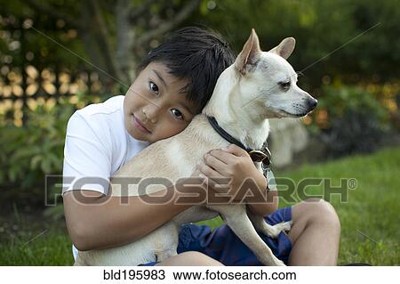 Mixed race boy hugging dog outdoors View Large Photo Image Stock Image - Mixed race boy hugging dog outdoors. Fotosearch