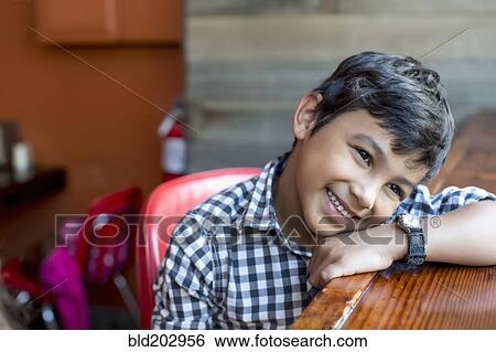 Stock Photograph - Mixed race boy leaning on bar. Fotosearch