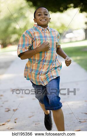 Stock Photograph - Mixed race boy running on sidewalk. Fotosearch