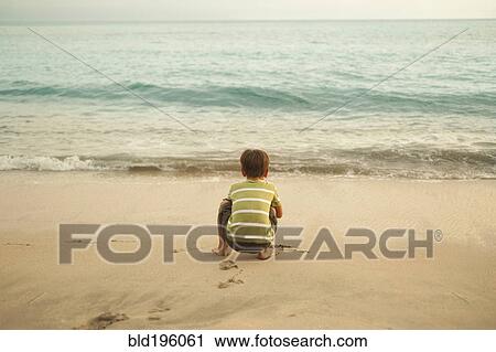Mixed race boy squatting on beach playing View Large Photo Image Stock Image - Mixed race boy squatting on beach playing. Fotosearch